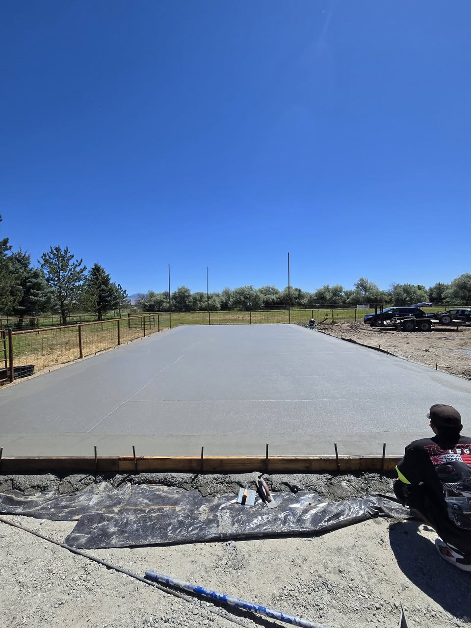 Freshly poured and finished concrete pad with forms still in place
